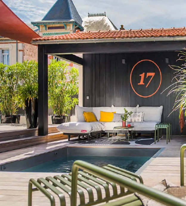 Piscine extérieure, canapé-lit gris, plantes en pot, et numéro 17 sur mur noir à l'Ile de Ré en Charente-Maritime 17