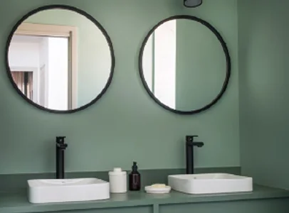 Double vasque de salle de bain moderne avec miroirs ronds et murs verts à l'Ile de Ré en Charente-Maritime 17