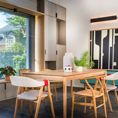 Salle à manger moderne avec table en bois, chaises élégantes, et grande fenêtre.